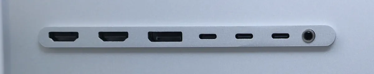 Close-up van de rij aansluitingen van de Kuycon G32P-monitor: twee HDMI-poorten, een DisplayPort, drie USB-C-poorten en een jackaansluiting